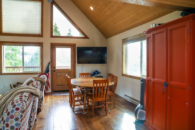 dining space with baseboard heating, wood-type flooring, vaulted ceiling, and a wealth of natural light