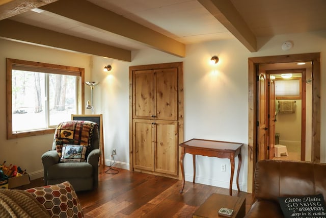 sitting room with dark wood-type flooring and beam ceiling