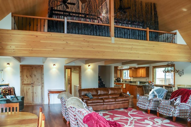 living room featuring a towering ceiling, hardwood / wood-style floors, and an inviting chandelier