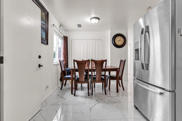 dining space featuring visible vents, marble finish floor, and baseboards