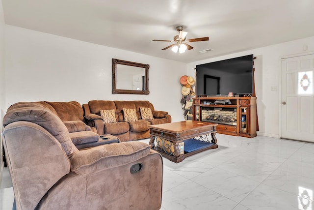 living area featuring visible vents, baseboards, marble finish floor, and a ceiling fan