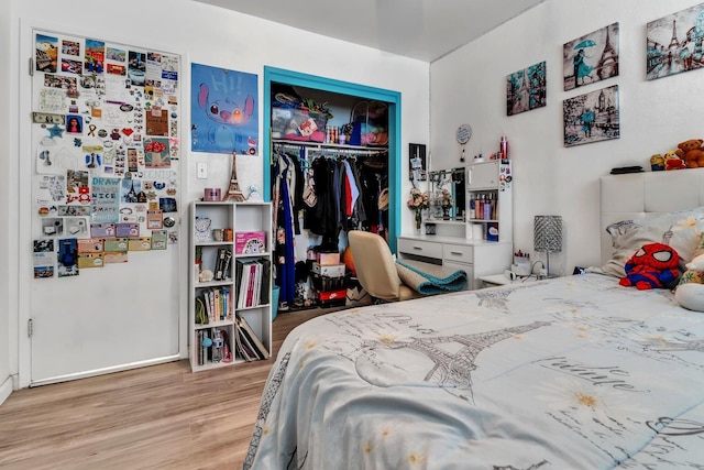 bedroom with fridge, wood finished floors, and a closet