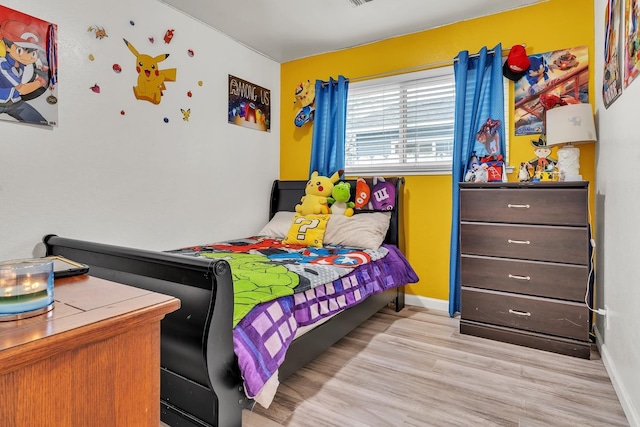 bedroom with light wood-type flooring and baseboards