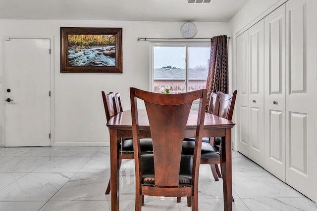 dining space featuring visible vents, baseboards, and marble finish floor