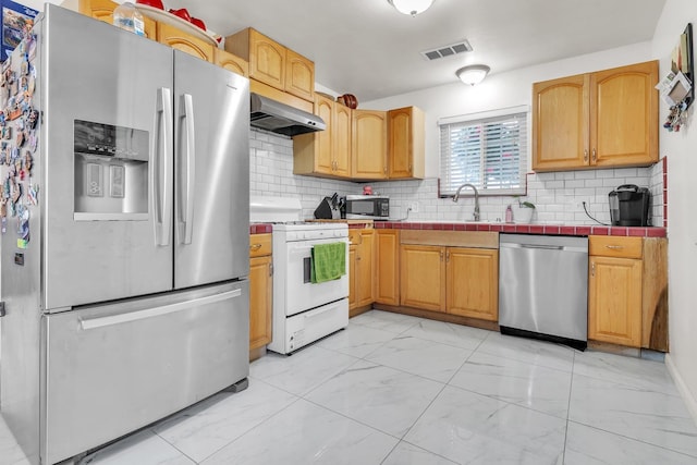 kitchen featuring visible vents, a sink, stainless steel appliances, under cabinet range hood, and marble finish floor