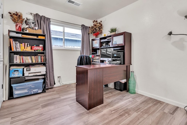 office area featuring light wood-style flooring, baseboards, and visible vents