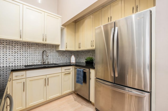 kitchen with sink, light hardwood / wood-style flooring, stainless steel appliances, decorative backsplash, and cream cabinetry