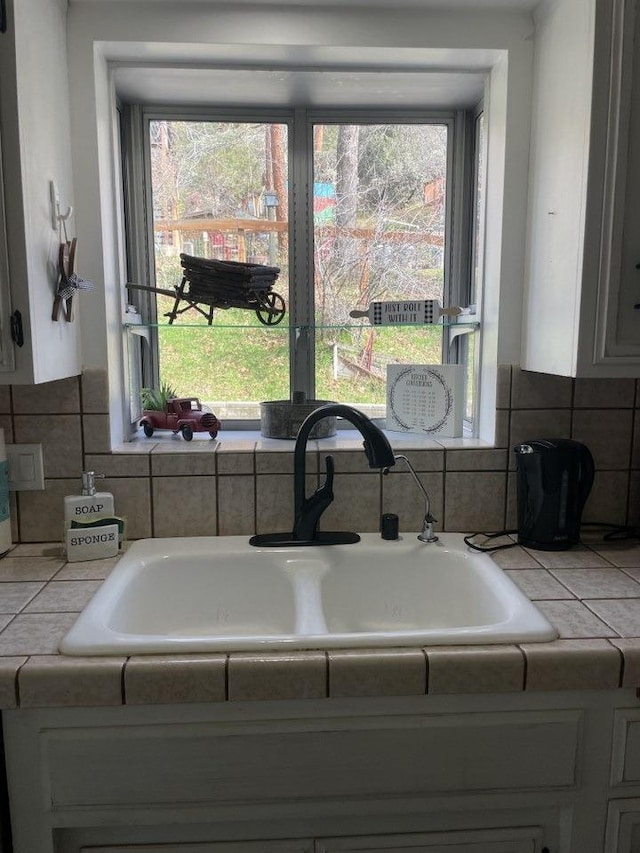 details with sink, backsplash, and tile countertops