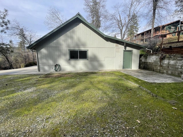 view of side of home with a patio area and a lawn