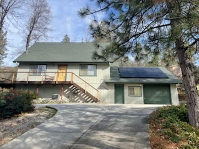 view of front of property with a deck and solar panels