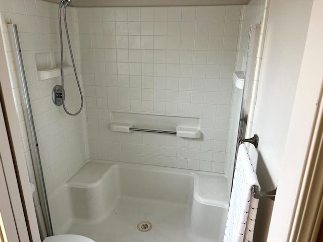 bathroom featuring a tile shower and toilet