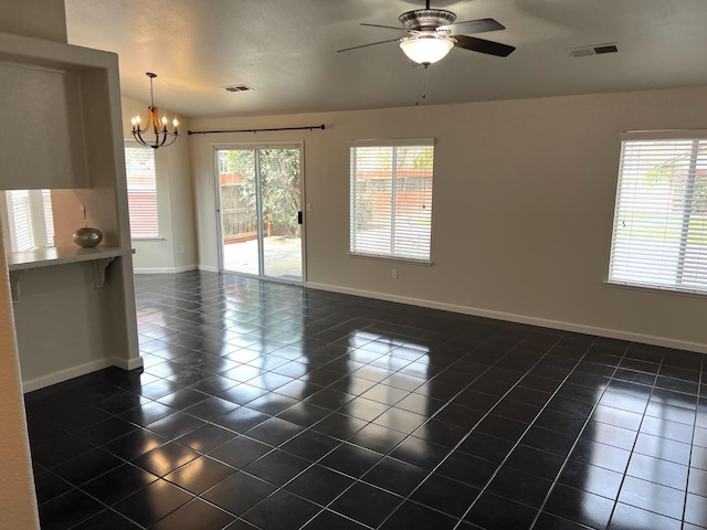 tiled empty room with ceiling fan with notable chandelier