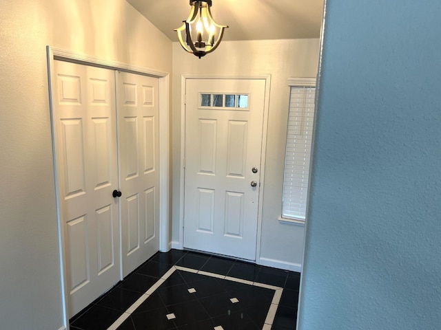 tiled entrance foyer with a notable chandelier