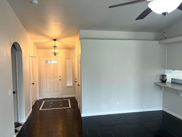 entryway featuring dark tile patterned floors and ceiling fan