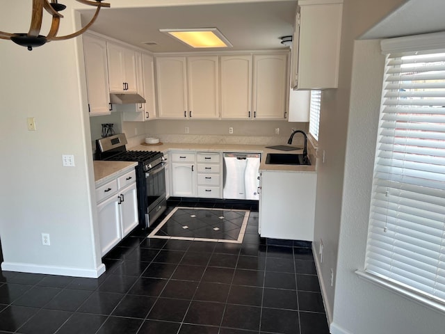 kitchen featuring white cabinetry, sink, stainless steel appliances, and dark tile patterned flooring