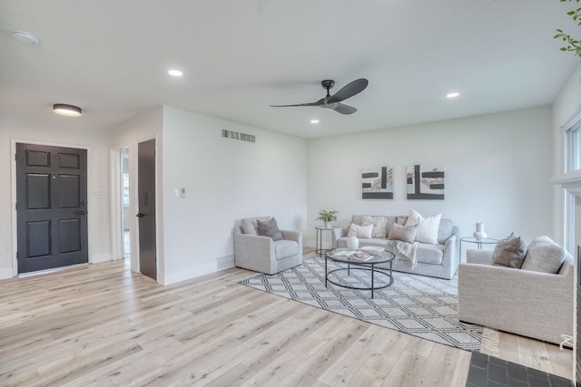 living room with ceiling fan and light hardwood / wood-style flooring