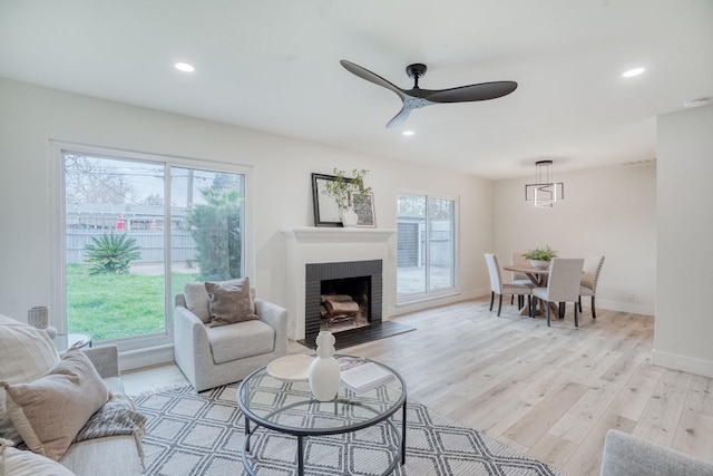 living room with a healthy amount of sunlight, ceiling fan, and light hardwood / wood-style flooring