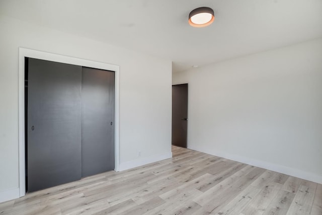 unfurnished bedroom with light hardwood / wood-style floors and a closet