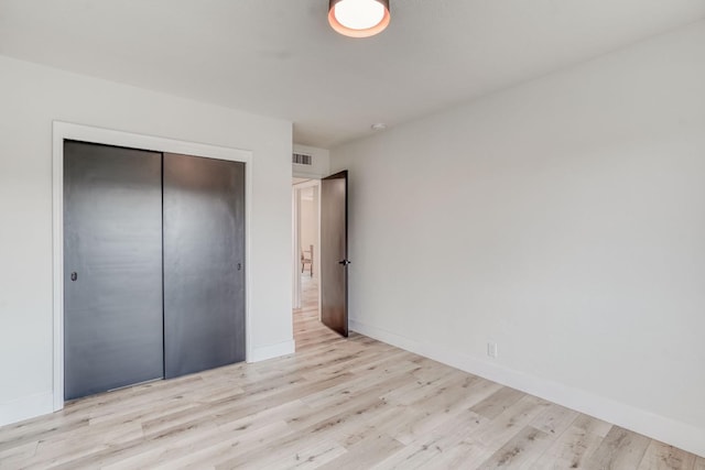 unfurnished bedroom featuring a closet and light hardwood / wood-style flooring