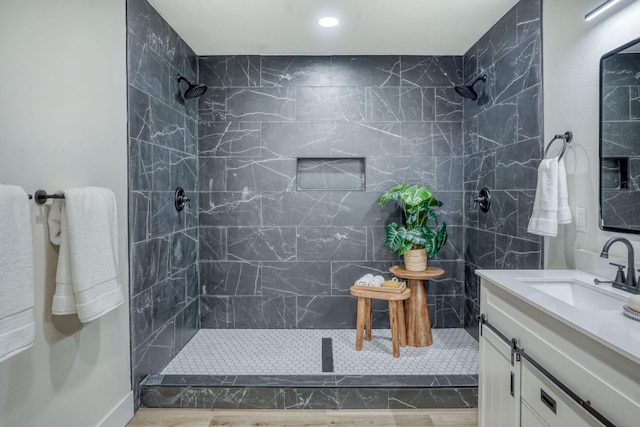 bathroom with vanity and a tile shower