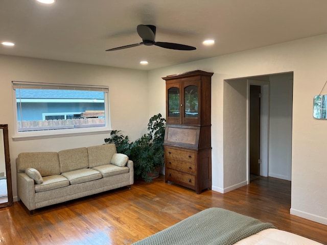 living room featuring dark wood-type flooring and ceiling fan