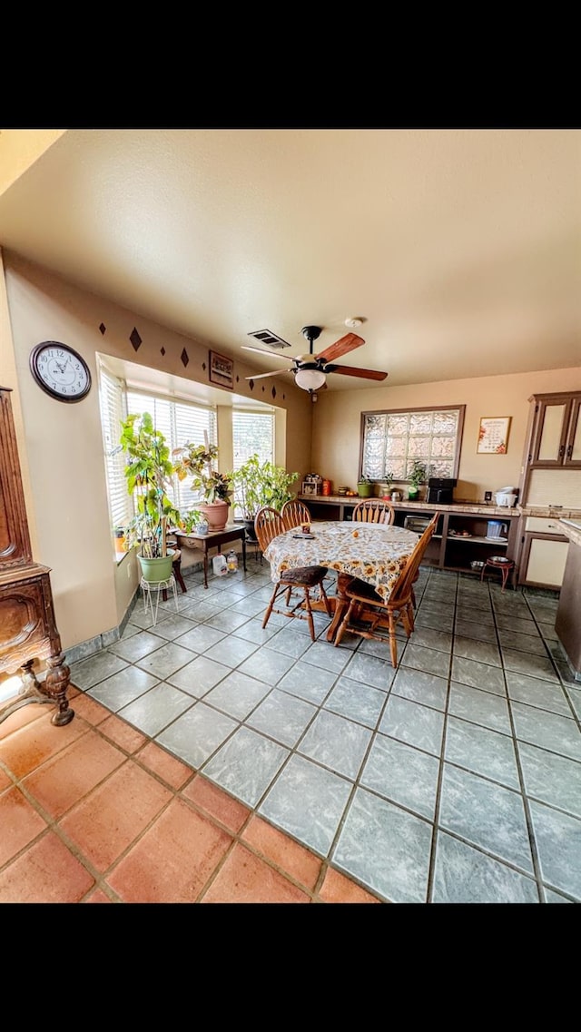 unfurnished dining area with tile patterned flooring and ceiling fan