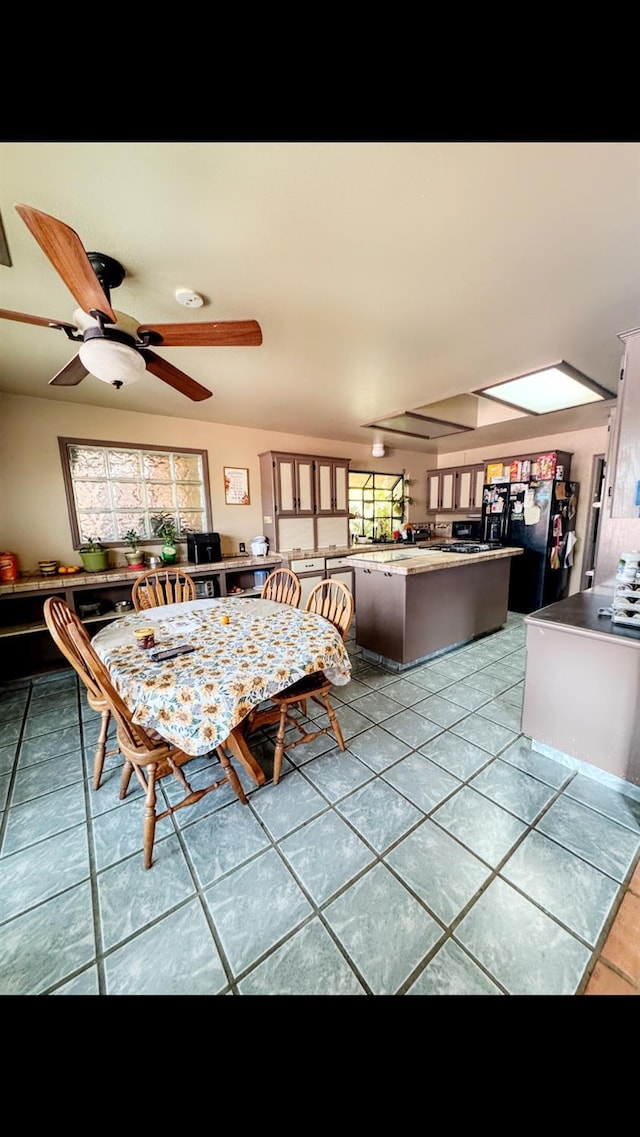 unfurnished dining area with ceiling fan and light tile patterned floors