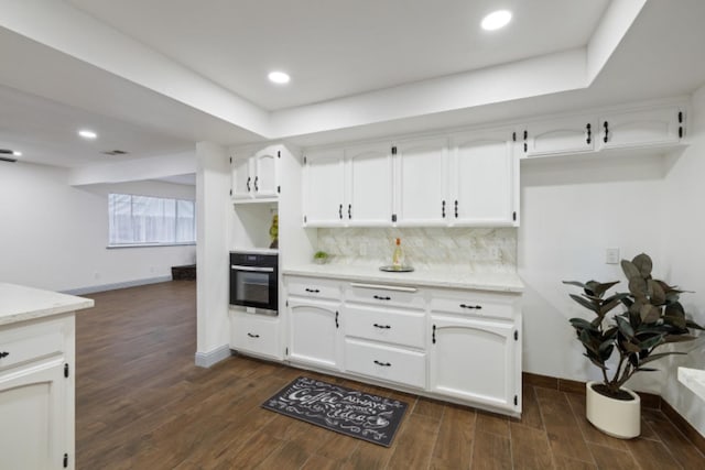 kitchen featuring white cabinetry, dark hardwood / wood-style floors, black oven, and decorative backsplash