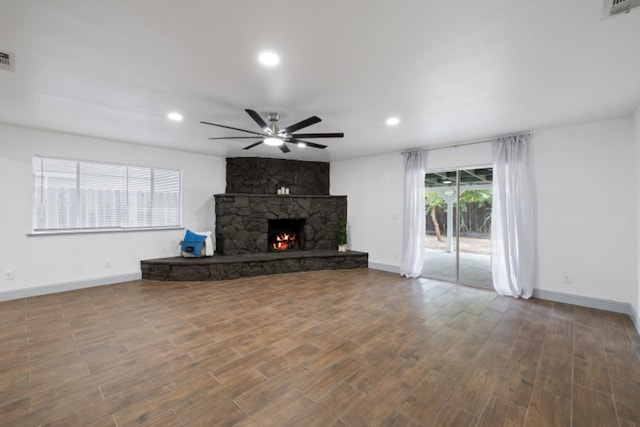 unfurnished living room with hardwood / wood-style flooring, ceiling fan, and a fireplace