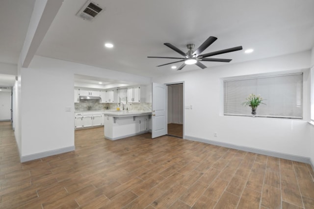 unfurnished living room with ceiling fan, sink, and dark hardwood / wood-style flooring