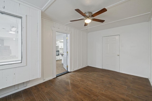 empty room with ceiling fan and dark hardwood / wood-style flooring