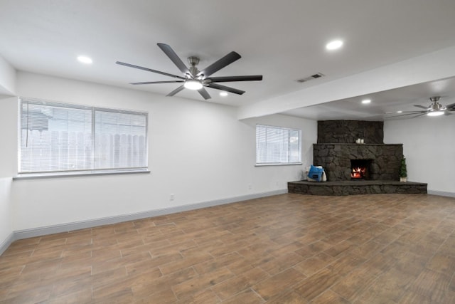 unfurnished living room featuring wood-type flooring, ceiling fan, and a fireplace