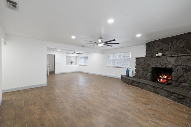 unfurnished living room featuring hardwood / wood-style flooring, ceiling fan, and a fireplace