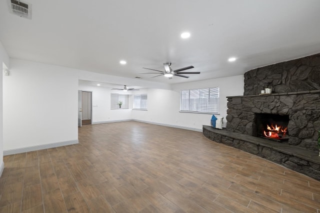 unfurnished living room with ceiling fan, wood-type flooring, and a fireplace