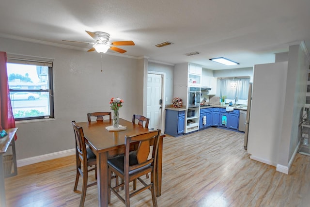 dining space with ceiling fan, ornamental molding, and light hardwood / wood-style floors