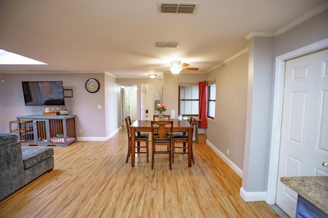 dining area featuring ceiling fan, ornamental molding, and light hardwood / wood-style floors