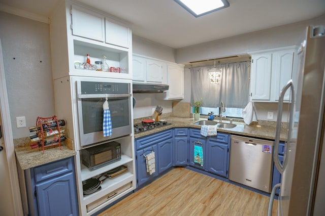 kitchen featuring blue cabinetry, sink, white cabinetry, light stone counters, and stainless steel appliances