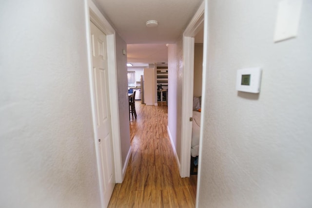 corridor with wood-type flooring