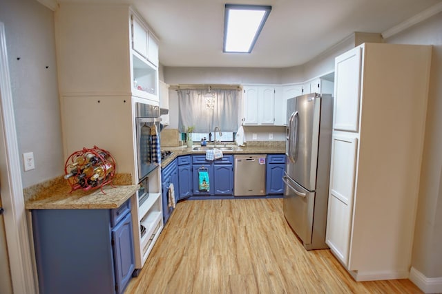 kitchen with sink, appliances with stainless steel finishes, light hardwood / wood-style floors, white cabinets, and blue cabinets