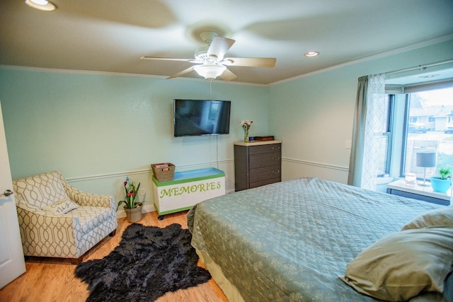 bedroom featuring ornamental molding, ceiling fan, and light wood-type flooring