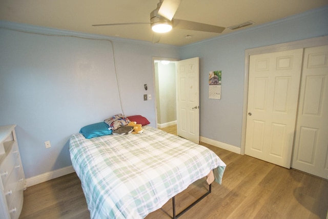 bedroom featuring wood-type flooring, ornamental molding, and ceiling fan