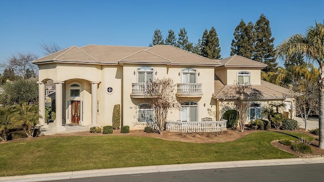 mediterranean / spanish home with a balcony and a front yard