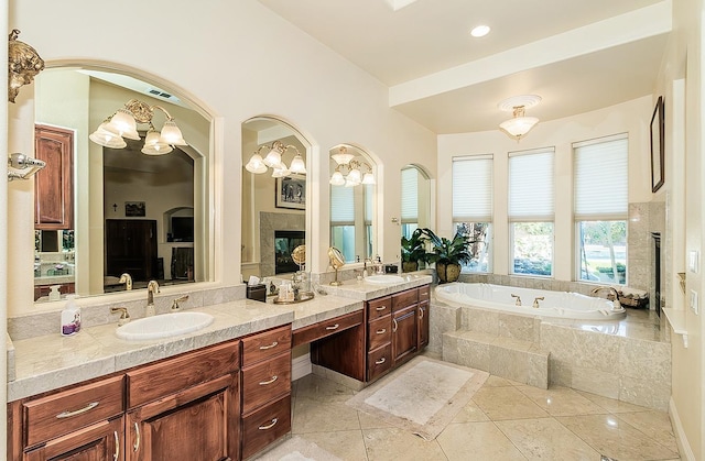 bathroom with vanity, a relaxing tiled tub, a fireplace, and tile patterned floors