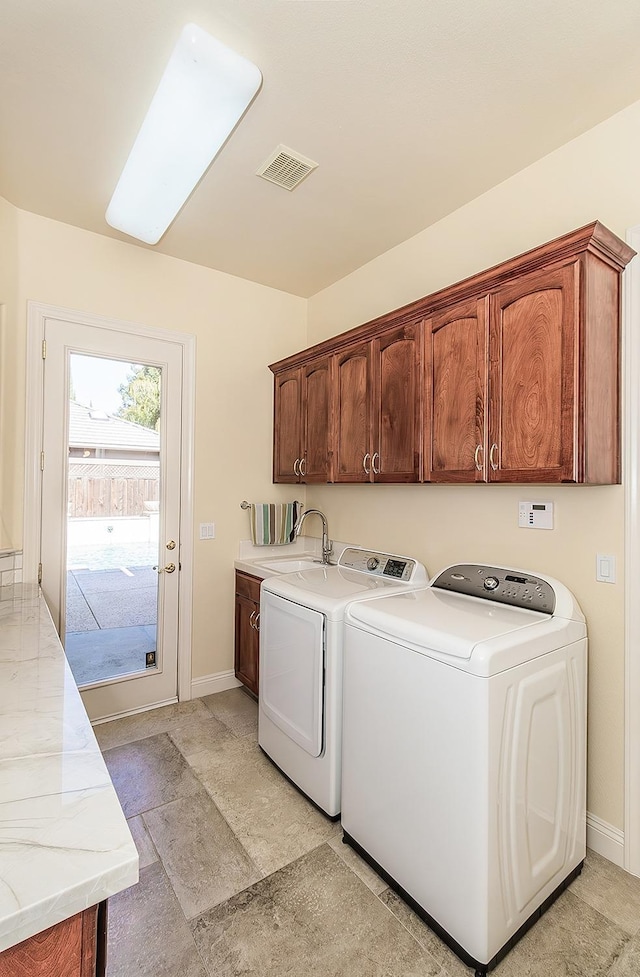 washroom with cabinets, sink, and independent washer and dryer