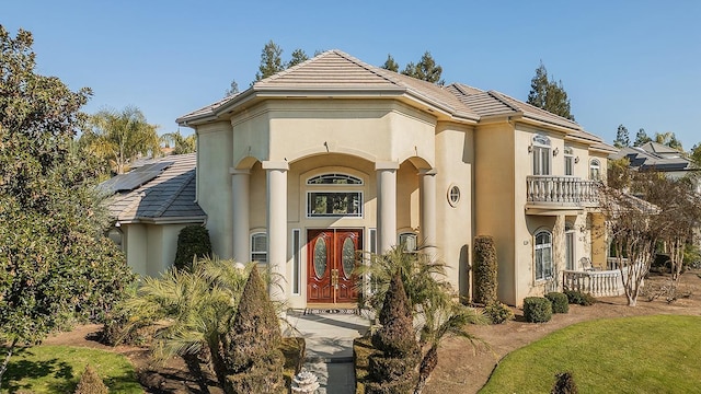 view of front of house with a balcony and solar panels