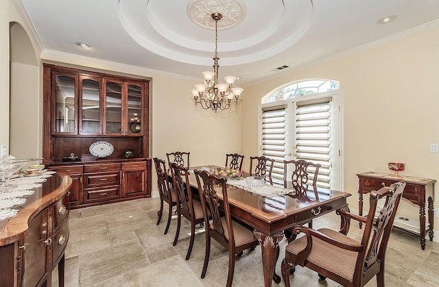 dining room featuring crown molding, a notable chandelier, and a tray ceiling