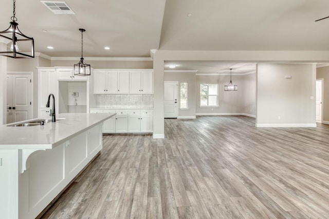 35710 Bonadelle Ave, Madera, CA 93636 - kitchen featuring a sink, tasteful backsplash, baseboards, visible vents, and crown molding