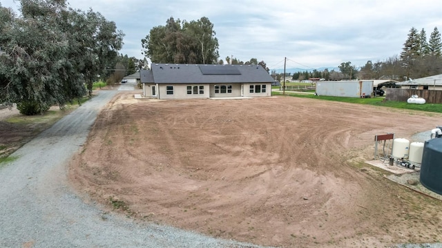 35710 Bonadelle Ave, Madera, CA 93636 - view of front of house with roof mounted solar panels, fence, and dirt driveway