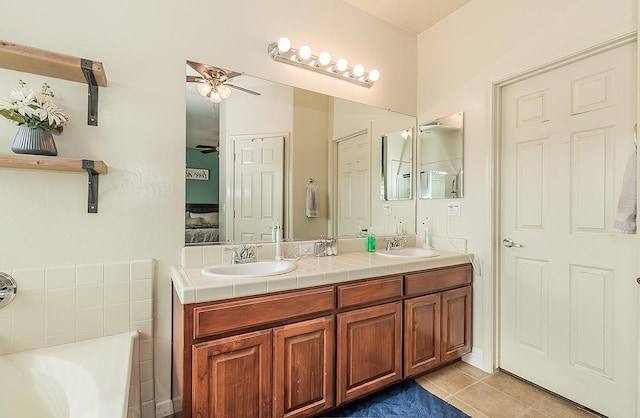 bathroom with ceiling fan, tile patterned floors, a bathing tub, and vanity