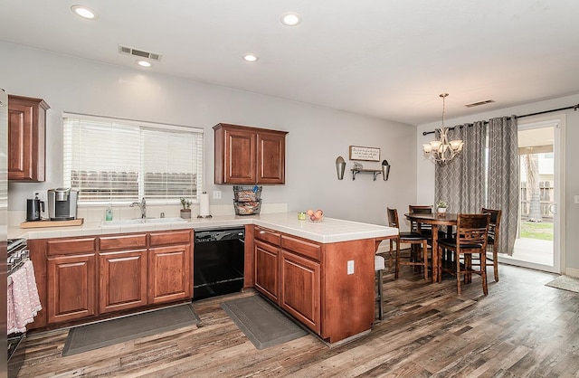 kitchen featuring a wealth of natural light, black dishwasher, sink, and kitchen peninsula